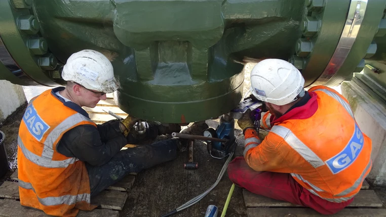 Two National Grid maintenance workers repairing a gas pipeline 