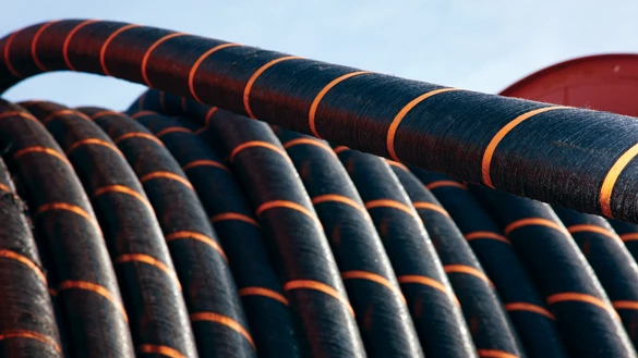 A large coil of black and orange cabling with a blue sky in the background 