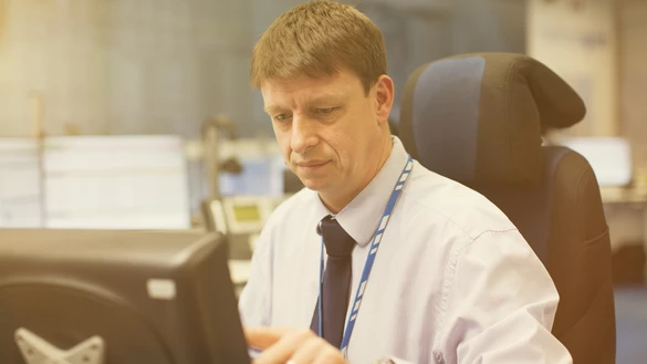 A National Grid employee working at a screen inside an office space 