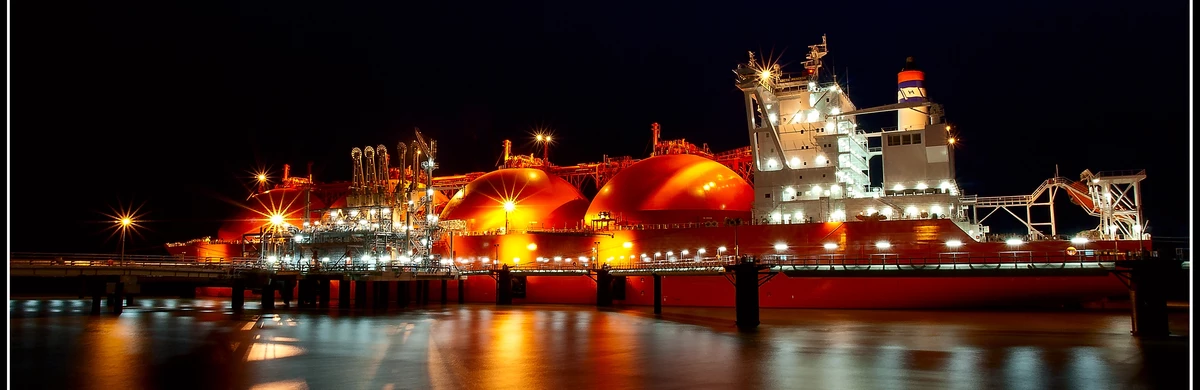 A ship brightly-lit on the sea at night-time 