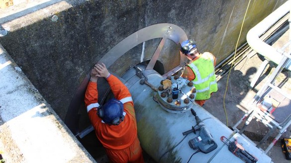 Two National Grid workers performing maintenance on an underground gas pipe